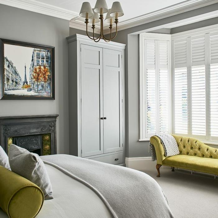 barokinė garstyčių spalvos sofa šiuolaikiškame suaugusiųjų miegamajame, barokinė lubų lempa, pilka drabužių spinta, Eifelio bokšto tapyba