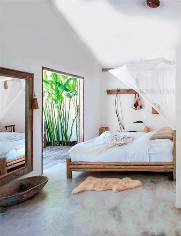 miegamasis su šviesia bambuko lova ir smėlio spalvos dirbtinio kailio kilimėlis
