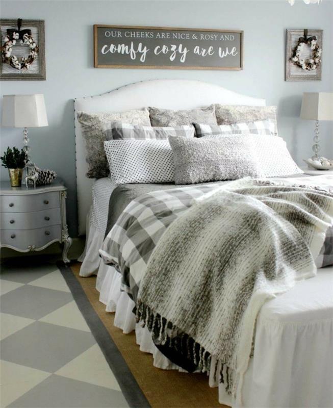 gri bir yatak odasında koza dekoru, barok başucu, birkaç gri minder, ahşap zemin, geometrik halı