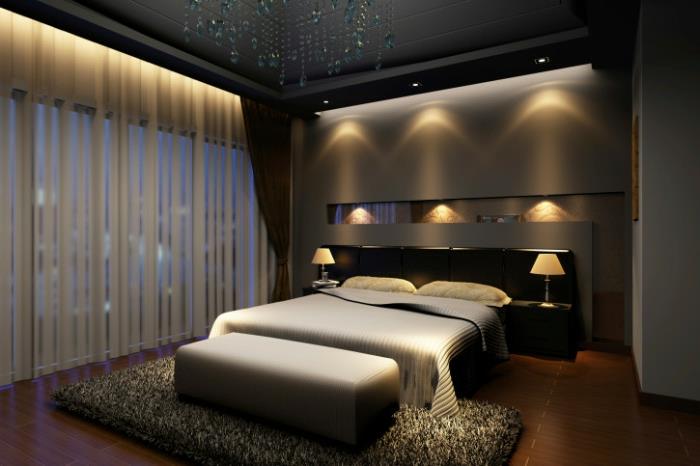 miegamojo sienų dekoras pilkos ir taupe spalvos, įleidžiamas lempos apšvietimas, ilgas polinis kilimas, baltos užuolaidos
