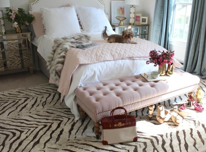 šiuolaikiška suaugusiųjų miegamojo apdaila, kilimėlis su gyvūnų raštais, rožinė miegamoji sofa, rožinis lovos užsegimas, krepšys ir aukštakulniai bateliai