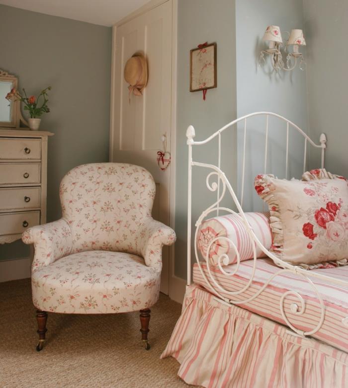 dekor podeželske spalnice, naslanjač liberty, rožnato in belo posteljnina, pastelno zelena stena, starinska bela komoda