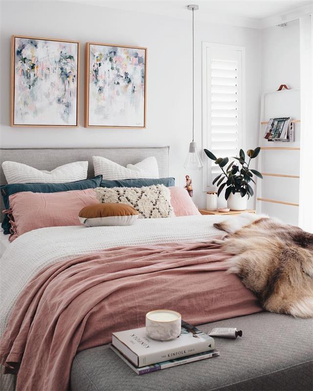 švelni ir moteriška atmosfera pastelinės rožinės spalvos miegamajame, povo mėlynos ir rožinės pagalvėlės pagal paveikslų spalvas