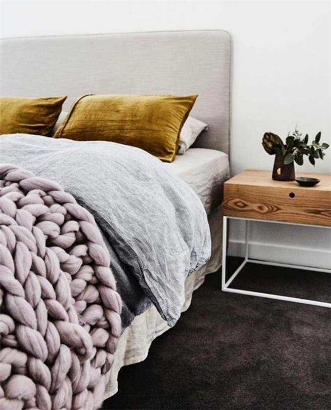 moderna-spalnica-roza-pletena-odeja-rumena-blazine-lesena-komoda