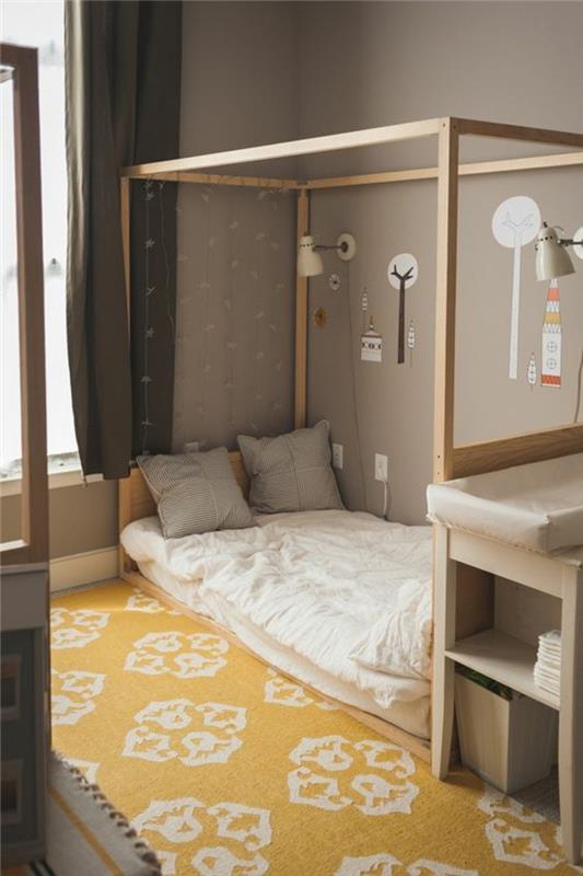 parmaklıksız bebek yatağı, arabesk desenli sarı ve beyaz halı, montessori kulübe yatağı, bebek bezini değiştirmek için mobilyalar, boz duvarlar