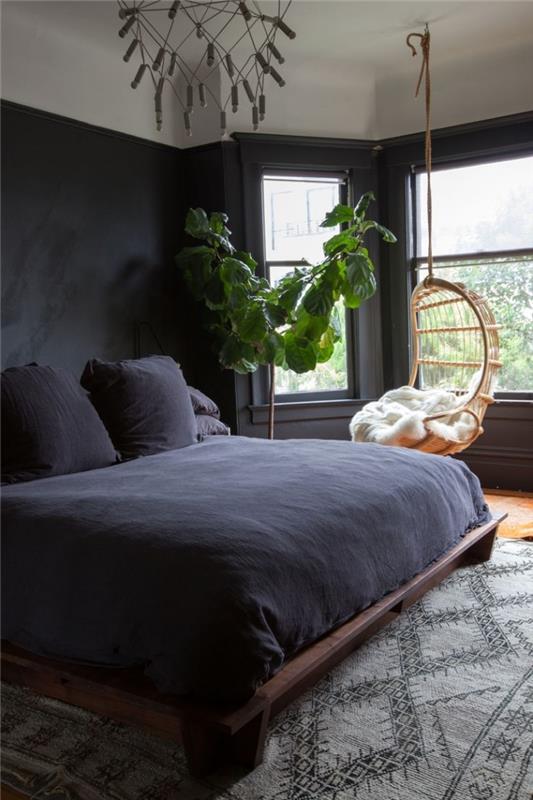 idėja, kaip papuošti kambarį tamsiomis sienomis, bohemiško prašmatnaus stiliaus interjero modeliu su kabančia kiaušinių kėde ir egzotišku žaliu augalu