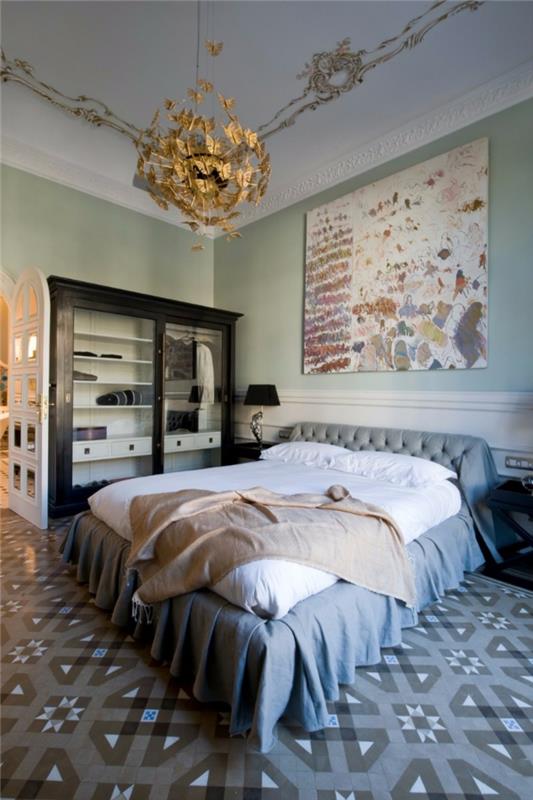 rožinis lovos užtiesalas, pilkas lovos užmetimas, originali lubų lempa, cementinės plytelių grindys, moderni suaugusiųjų miegamojo apdaila