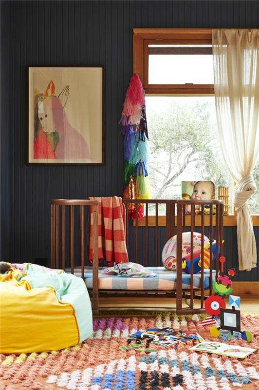 duvarda kırmızı ve mor renklerde büyük resim ve büyük bir pencere ile ördek mavi bebek odası