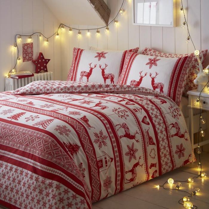 raudona ir balta dvigulė lova, šviesi girlianda, balta sienų apmušalai, baltas medinis naktinis stalas, jaukus skandinaviško stiliaus miegamasis