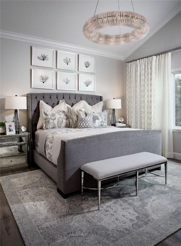 modernus suaugusiųjų miegamasis, pilka kušetė, originalus lubų šviestuvas, dekoratyviniai rėmai, pilkas kilimas
