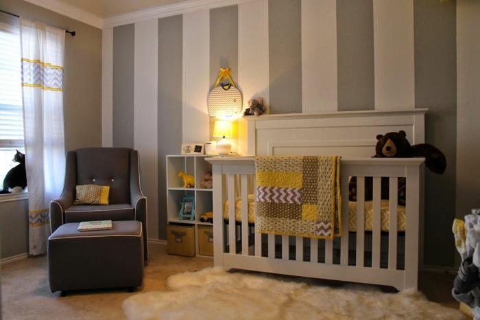 kūdikio kambarys, pilkas fotelis, baltas kailinis kilimas, pilka ir balta siena