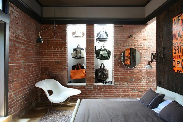originalus miegamasis, atvira plytų sienų danga, apvalus pakabinamas veidrodis, plastikinė kėdė