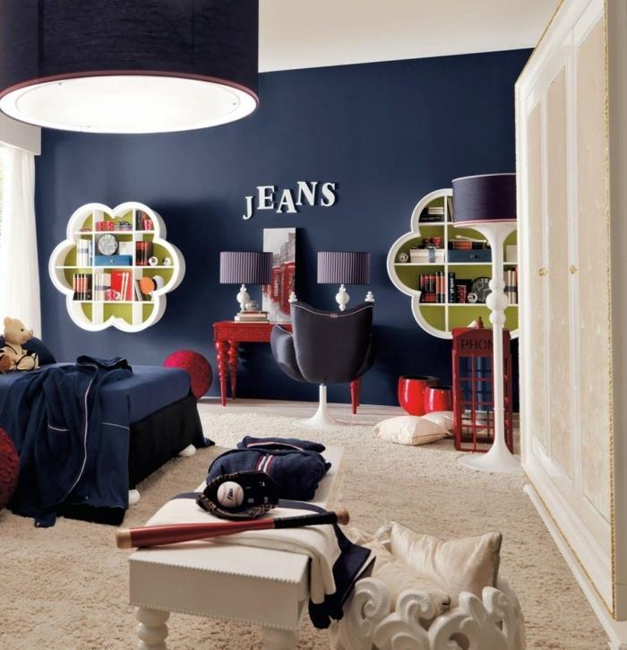 tapybos vaikų kambarys, pakabinama lempa, originalios formos lentyna, tamsiai mėlyna siena, mažas raudonas stalas, baltas žurnalinis staliukas