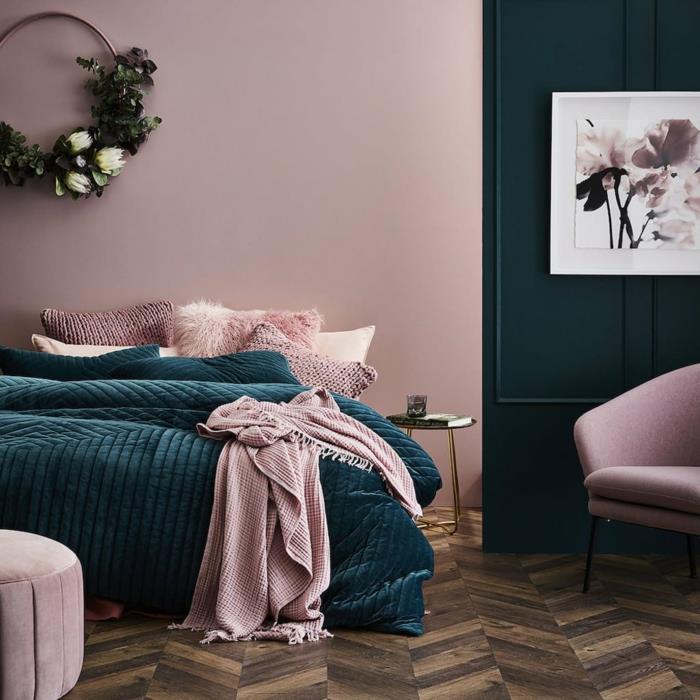 rožinis suaugusiųjų miegamojo paveikslas, rožinė taburetė ir fotelis, ševrono parketas, dirbtinis augalų dekoratyvinis vainikas, abstraktus paveikslas