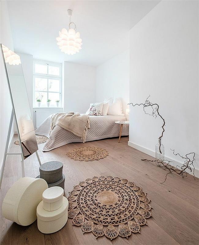 „macrame“ kilimas, baltos sienos dideliame jaukiame miegamajame, stačiakampis veidrodis, balta lubų lempa