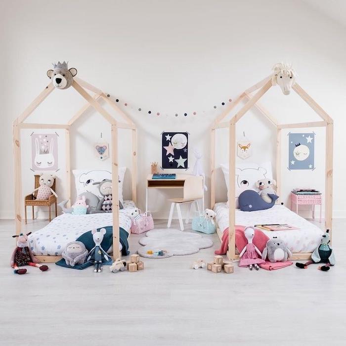 medinė Montessori namelio lova, šviesaus medžio parketas, žaidimų kilimėlis, stalas ir kėdė, daugybė žaislų visur