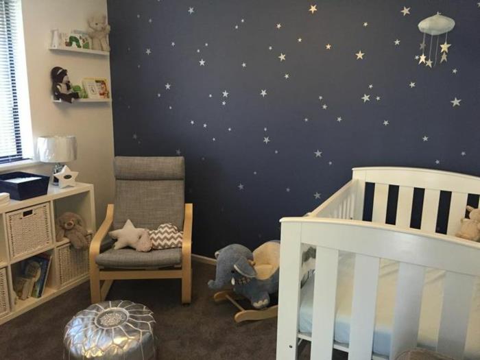 žvaigždėto dangaus siena, pilka kėdė, balta kūdikio lovelė, sidabrinis marokietiškas pufas, lopšys prie dramblio