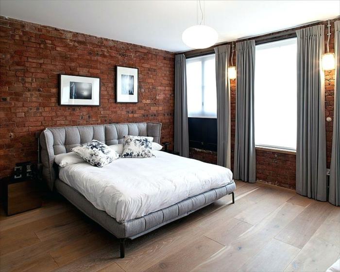 miegamasis pilkos, baltos ir mūrinės sienos, pilkos užuolaidos, medinės grindys, sieniniai šviestuvai
