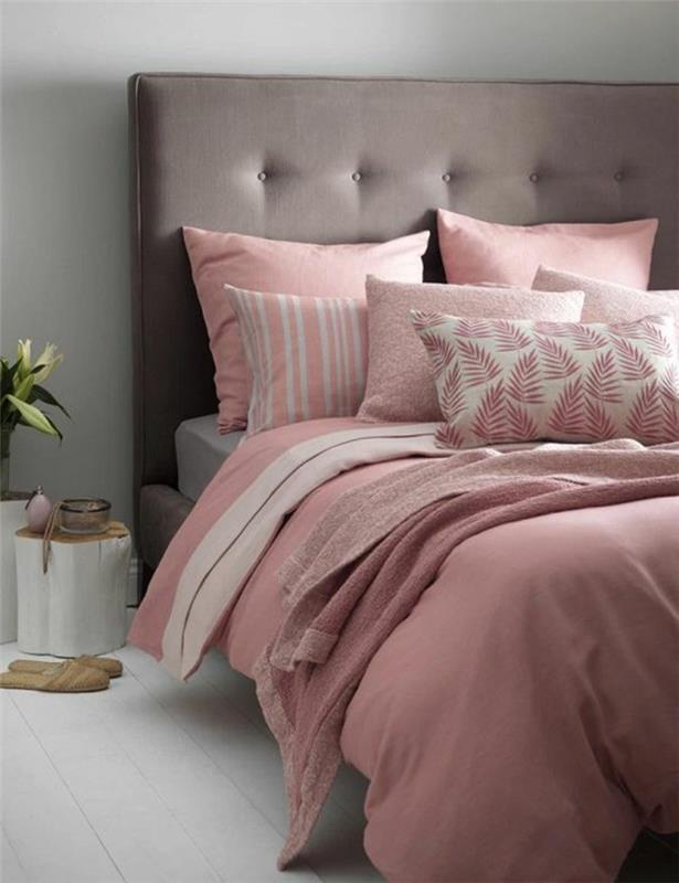 siva in roza spalnica, roza in bele blazine, sivo oblazinjeno vzglavje, postelja ob prtljažniku