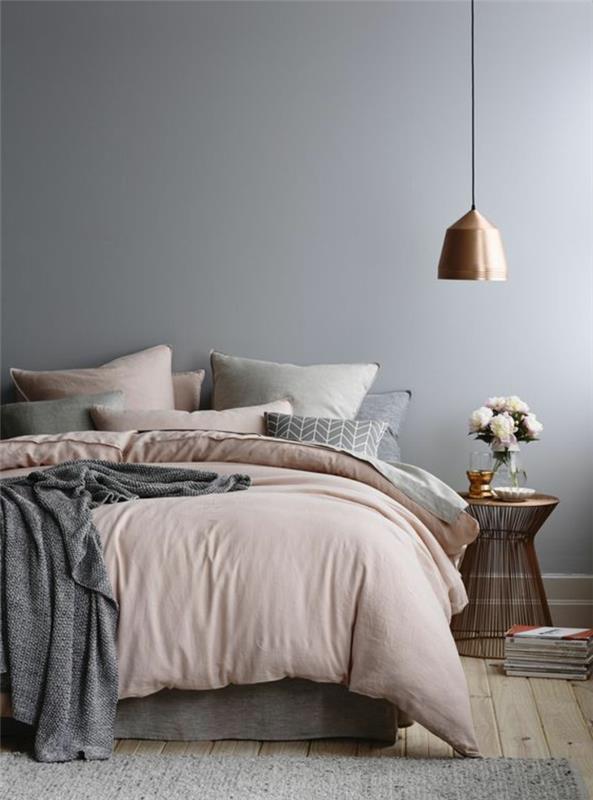 siva spalnica, bakrena viseča svetilka, siva stenska barva, okrasne blazine