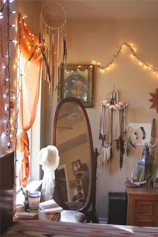 bohemiškas dekoras, didelis veidrodis, šviesi girlianda, svajonių gaudyklė, medinė spintelė