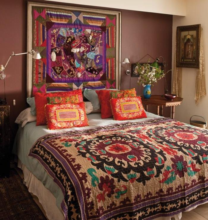 hipių dekoras, raudonos pagalvėlės, etninio rašto pledas, medinis naktinis stalas