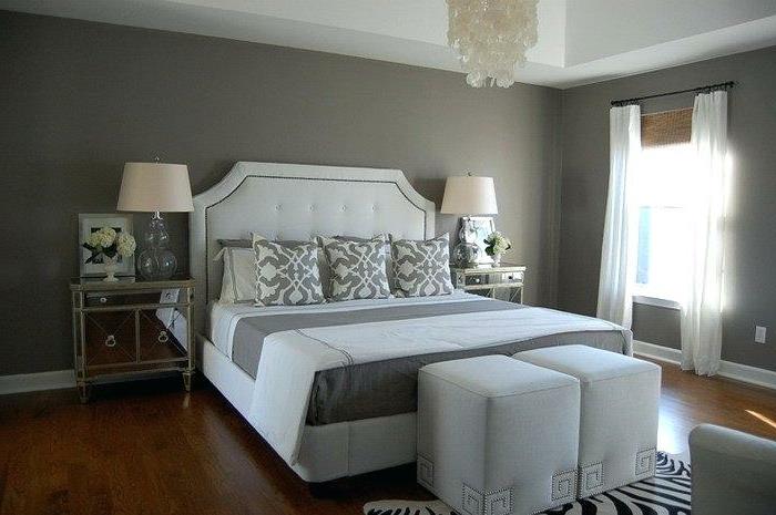 moderni suaugusiųjų miegamojo apdaila, didelė pilkos ir baltos spalvos lova, kubinės išmatos, zebro kilimas