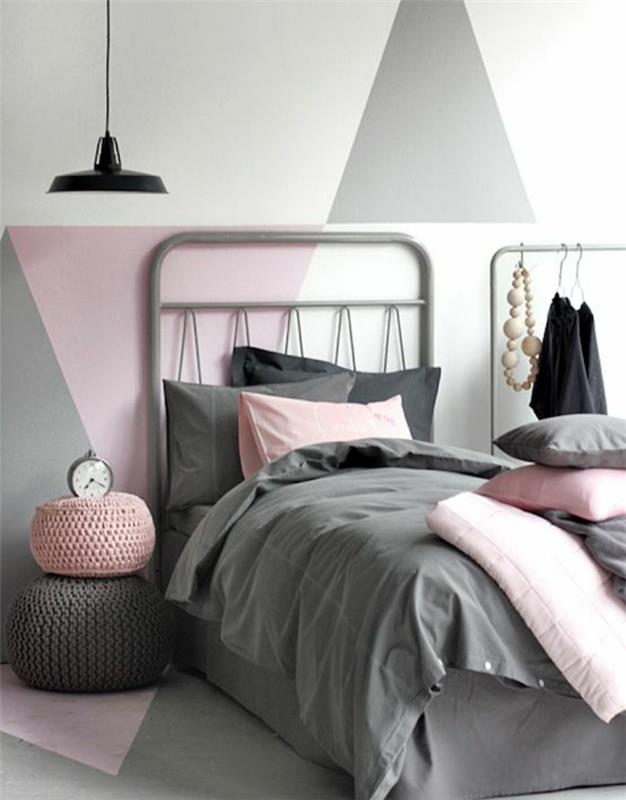 poslikava spalnice za odrasle, siva, roza in bela trikotna stena, siva posteljnina z rožnatimi blazinami, spalnica v kokonu