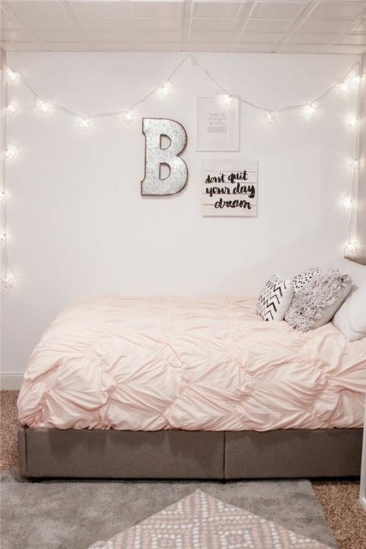roza in siva spalnica, bledo siva stena in svetel girland, okrasna črka na steni