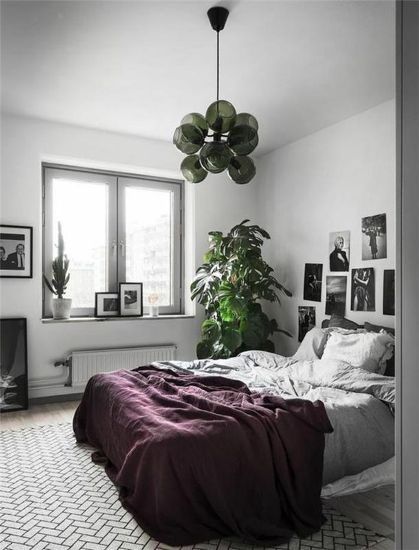 skandinaviškas miegamojo dekoras pilkai baltos ir juodos spalvos sienų apdaila-juodai-balta-nuotraukos-pilka-antklodė-bordo-augalas ir žalias žibintų stulpas
