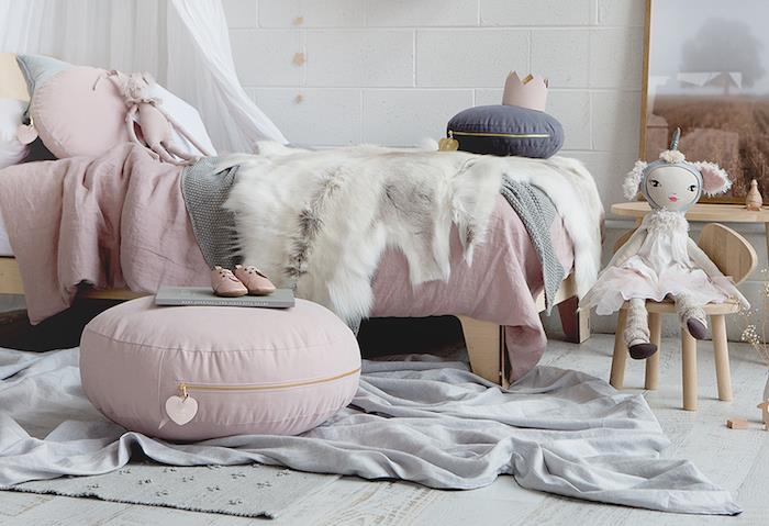 medinė kūdikio mergaitės lova su šviesiai rausva apdaila ir skandinaviško stiliaus baldais