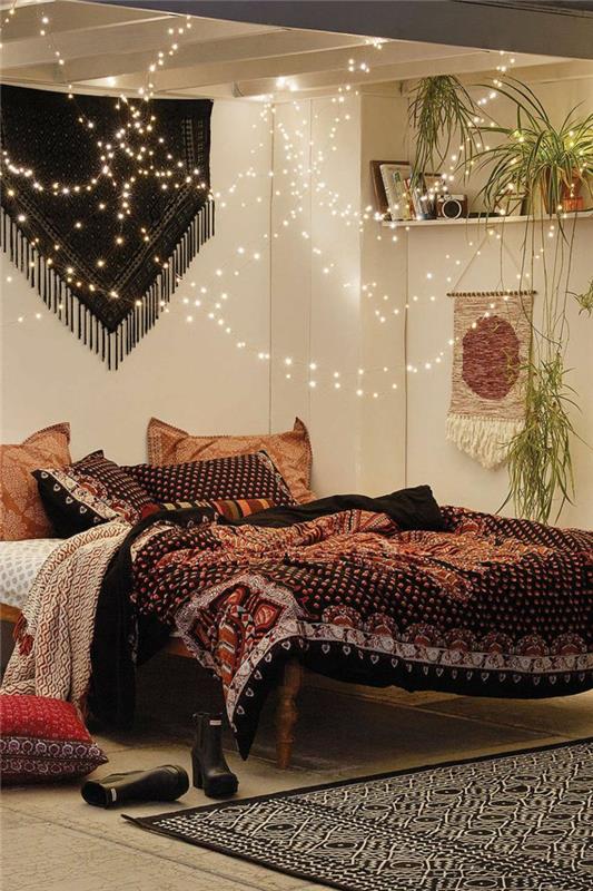 spalnica v slogu boho chic, etnična postelja, bele stene, stensko obešanje, lesena tla