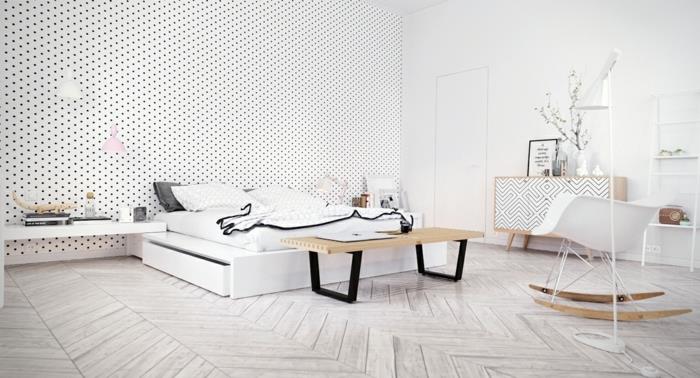 miegamasis-visi baltai balti-tapetai-su-mažais-juodais taškeliais-nestandartiniai baldai su geometriniais raštais-skandinaviškas supamasis krėslas-skandinaviškas parketas
