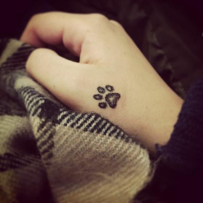 mačja tetovaža, mačja šapa na roki, tetovirana s črnim črnilom
