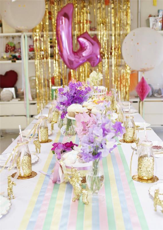 dekliška miza v pastelnih in zlatih barvah na temo samoroga z belim pokrovom za prt in črtasto mizo