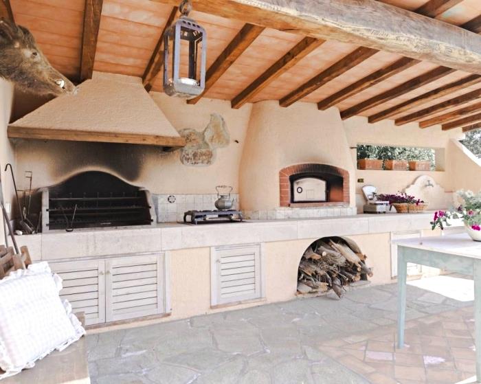 dengtos vasaros virtuvės su medžio masyvo stogu ir didelėmis akmeninėmis grindimis, kaimiško ir kaimo stiliaus virtuvės dekoro pavyzdys