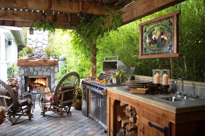 kaimiško stiliaus virtuvė su mediniu stogu ir akmeniniu židiniu, nerūdijančio plieno kepsninės pasirinkimas