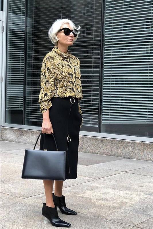 yılan desenli kadın gömleği ve orta uzunlukta siyah etek siyah deri çanta modern görünüm 60 yaşında kadın