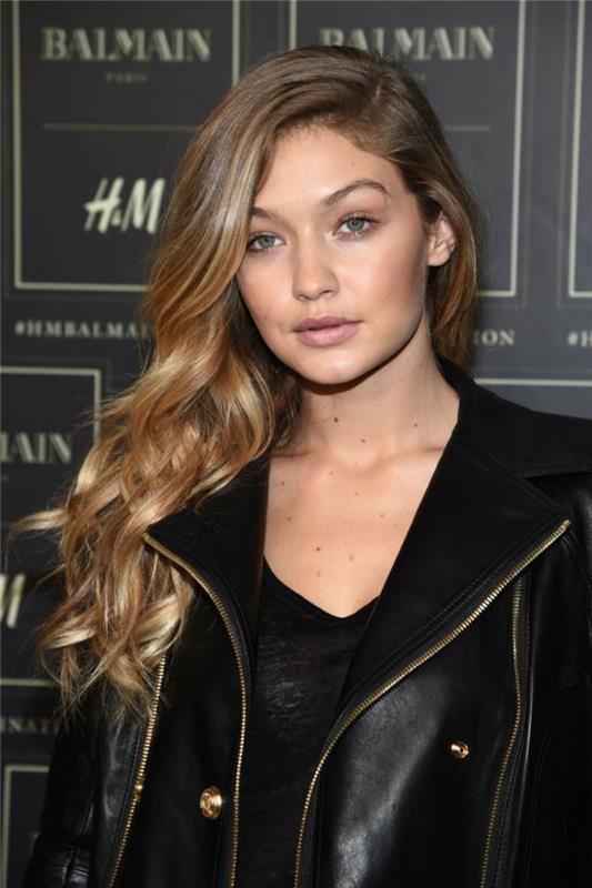 gigi hadid ir jos natūrali blondinė, karamelinė spalva su aukso atspalviais, prašmatni šoninė šukuosena