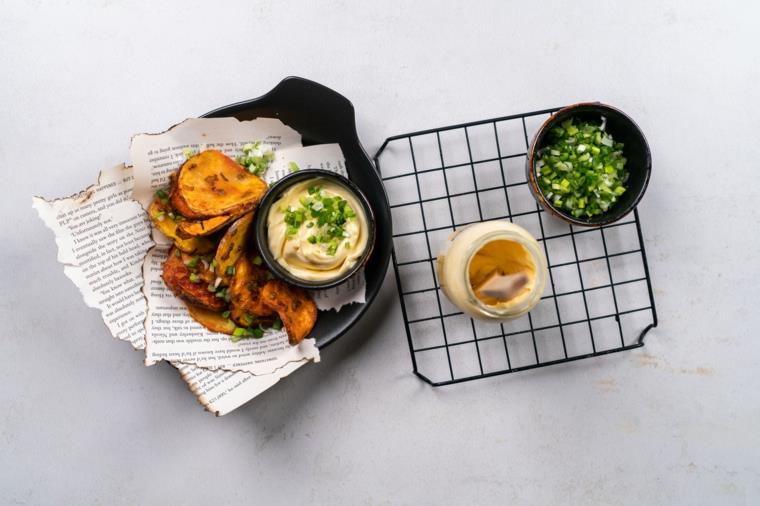 Patates sottili al forno, ciotola con maionese ve cipolla verde, barattolo di maionese