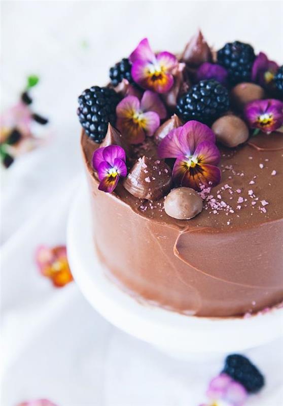 Minkštas ir švelnus šokoladinis pyragas yra lengvai pagaminamas gimtadienio tortas, papuoštas valgomomis gėlėmis ir miško vaisiais
