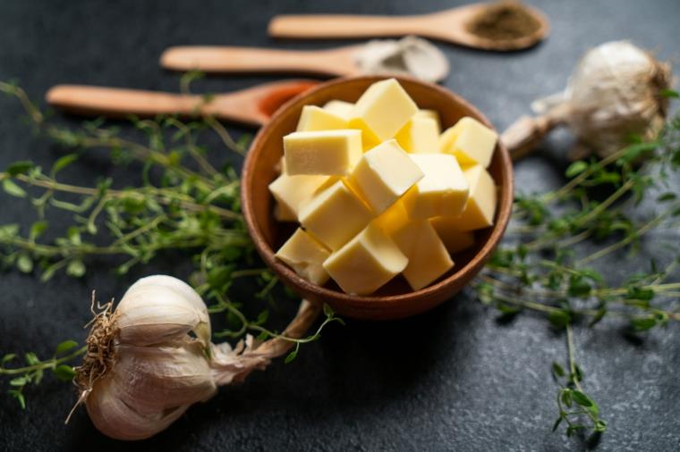 Ciotola di legno con cubetti di burro, ricetta per patata a fisarmonica