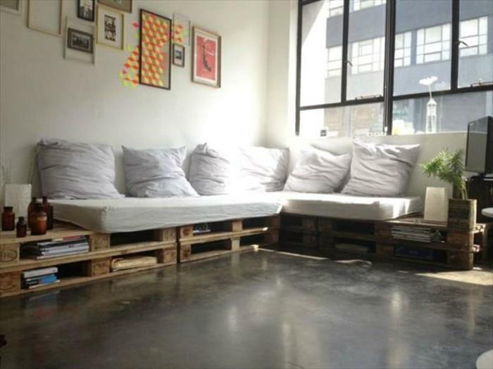 platus langas šalia kampinės sofos, padengtas daugybe baltų putų pagalvių, ir atitinkamos pagalvėlės, įrėminti meno kūriniai ant sienos, padėklo padėklas