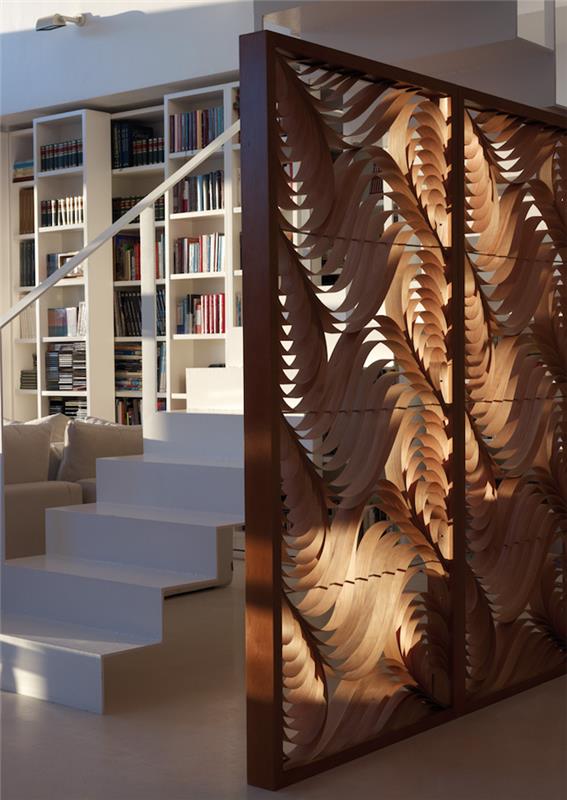 izrezljana lesena predelna stena kot bela notranja stena dnevne sobe s stopniščem v podstrešju