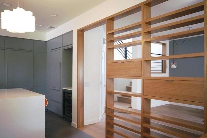 medinė pertvara su angomis ir sandėliuku atskiriant virtuvės ir svetainės tipo tvoras, interjero aptvėrimo su saugykla idėja