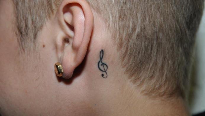 Justino Bieberio piešimas už ausies tatuiruotės muzikinės natos