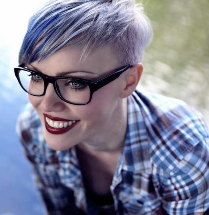 ljubki kratki odbitki, nasmejana ženska z globoko rdečo šminko in očala s črnimi okvirji, s kratkim stransko razrezanim pixie-jem, pobarvani v bledo vijolično in modro