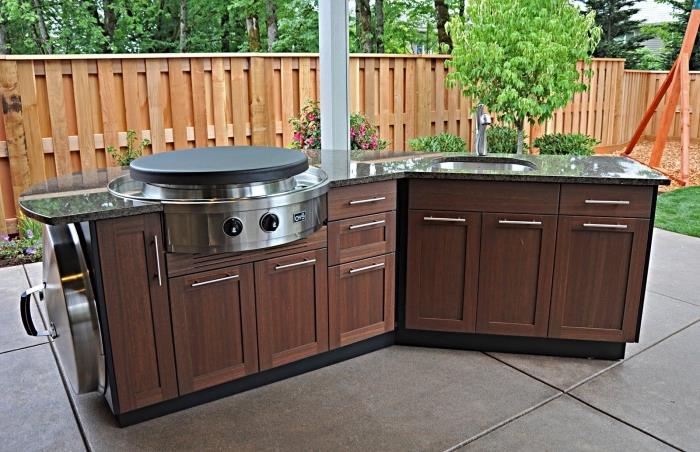 mini sodo virtuvės su plienine įranga granito stalviršio ir tamsaus medžio spintelių pavyzdys