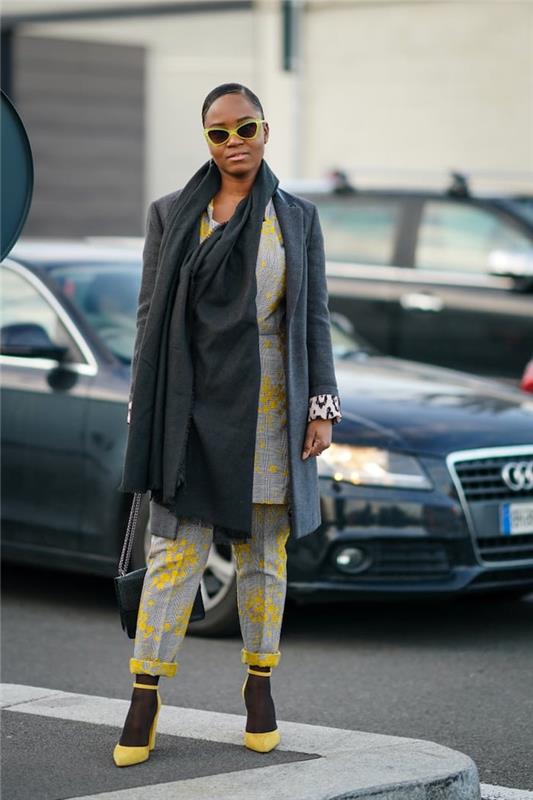barvna oznaka pantone ženska v sivi obleki in rumenih črpalkah s sončnimi očali pred avtomobilom