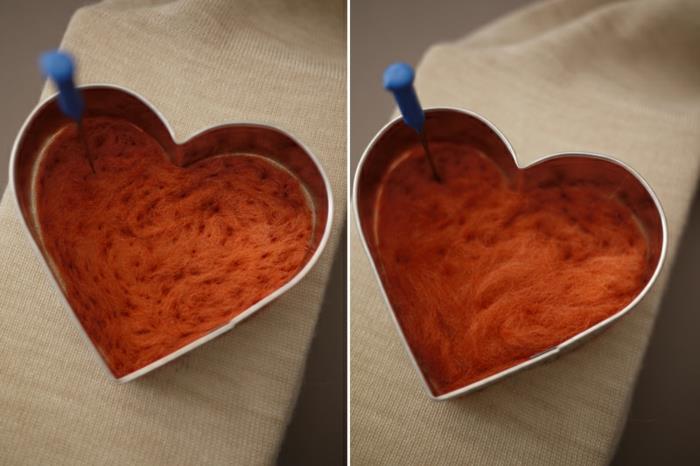 oranžinės vilnos širdis, suformuota naudojant širdies formą ir adatų techniką